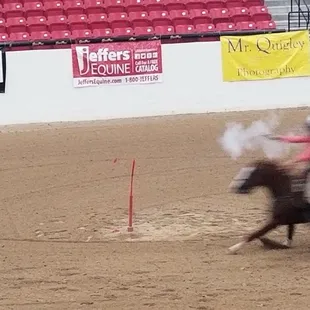 Cowgirl shooting a balloon while riding