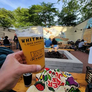 a person holding a glass of beer