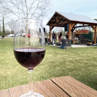 a glass of red wine on a picnic table