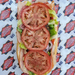 a sandwich with tomatoes and lettuce