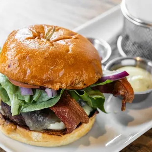 a burger with bacon, lettuce, and tomato