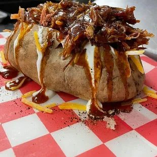a loaded baked potato on a red and white checkered tablecloth