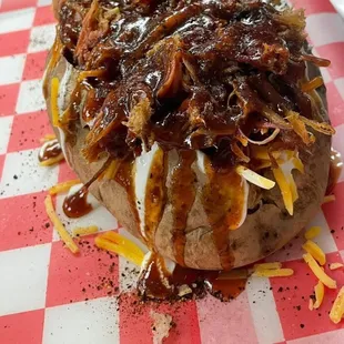 a baked potato covered in barbecue sauce