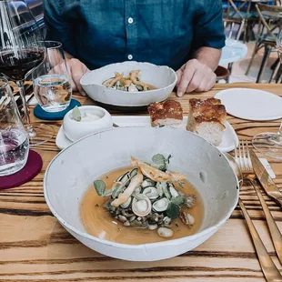 a man sitting at a table with a bowl of soup and bread