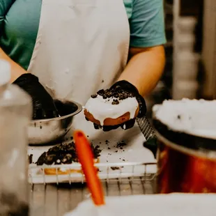 a woman preparing a doughnut