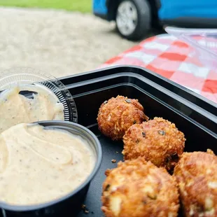 a tray of crab cakes and dipping sauce