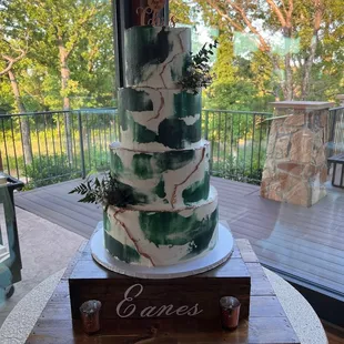 a three tiered cake decorated with greenery