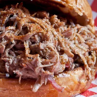 a pulled pork sandwich on a bun - stock image