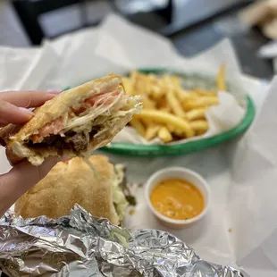 a hand holding a half eaten sandwich