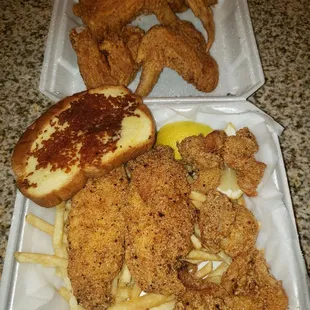 a chicken sandwich and french fries in a styrofoam container