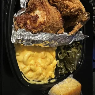 Fried chicken with macaroni and cheese and collard greens and a piece of cornbread