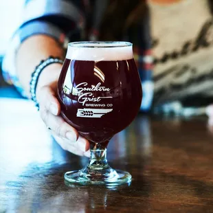 a person holding a glass of beer