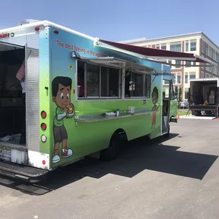 a green food truck parked in a parking lot