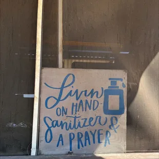 a sign that reads living on hand sanitiers a prayer