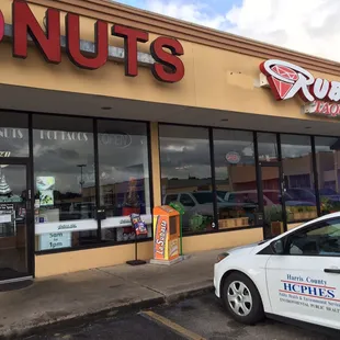 a woman standing in front of a donut shop