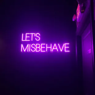 a neon sign that says let's misbehave