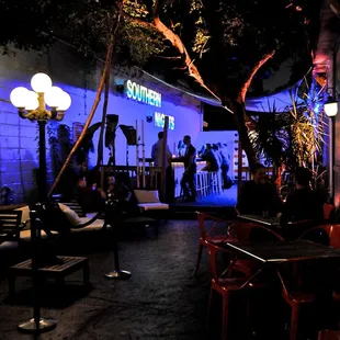 people sitting at tables outside a bar