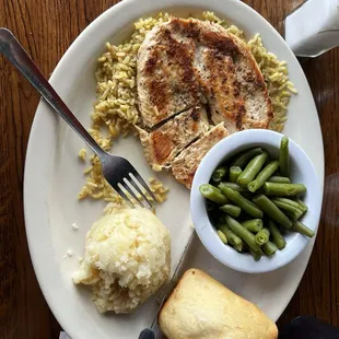 Grilled chicken , mashed potatoes, green beans and a roll of