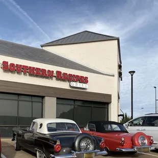 several classic cars parked in front of a restaurant