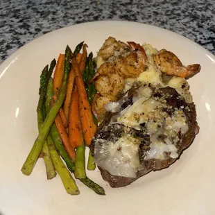 a plate of food with shrimp, asparagus, and carrots