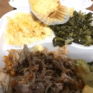 pulled pork, potatoes, and greens in a styrofoam container