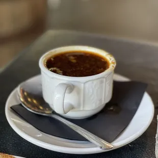 a cup of soup and toast on a plate