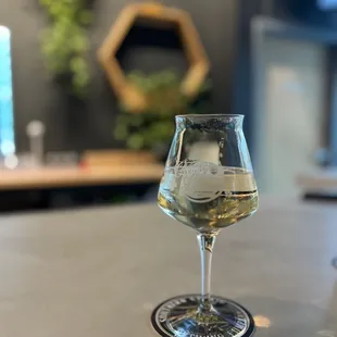 a glass of white wine on a table