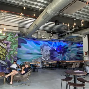 a woman sitting in a chair in front of a mural