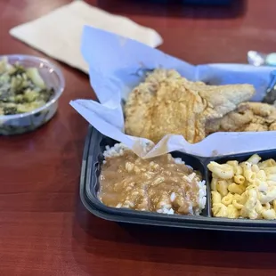 Fried pork chops, collard greens, rice and gravy, and macaroni and cheese.