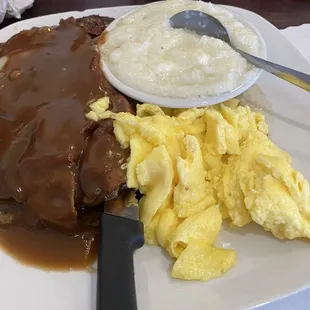 Smothered liver and onions with bacon, eggs and grits.