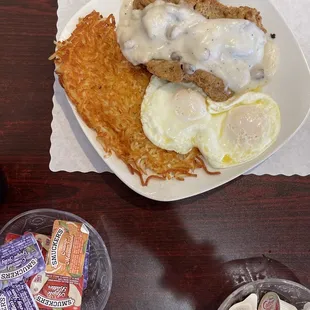 Country fried steak and over easy eggs plus hash browns.
