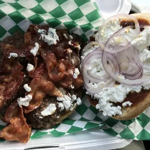 a burger with bacon, cheese, and onions