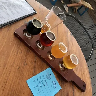 A flight of draft beers; Fuzzy Bastard, Hefeweizen, Flex Squad, and Rasputins Daughter, and in the back is the Work like a Captain.