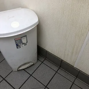 a white trash can with stickers on it