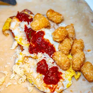 a person's hand preparing a burrito