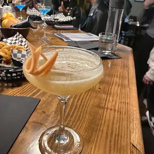 a cocktail in a coupe glass on a bar