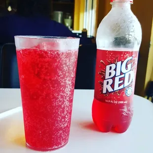 a bottle of big red soda and a glass of soda