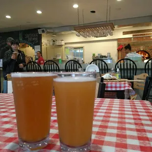two glasses of beer on a checkered tablecloth