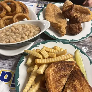 Catfish dinner with white beans, onion rings and hush puppies . BLT on sourdough with crinkle cut fries