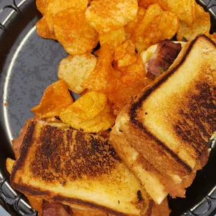 a plate of potato chips and a grilled cheese sandwich