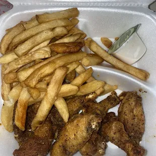 chicken and french fries in a styrofoam container