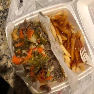 a sandwich and french fries in a styrofoam container