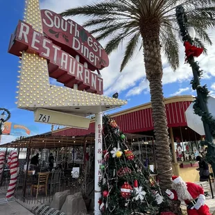 a christmas tree in front of the sign