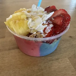 Smoothie bowl topped with pineapple, coconut and strawberries.