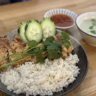 a plate of rice, cucumber, and meat