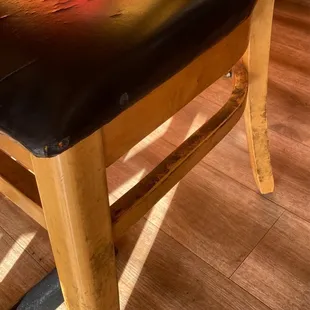 a wooden chair with black leather seat