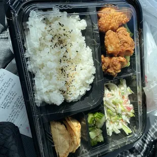 Bento with karage, slaw, white rice, and gyoza.