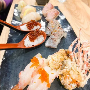 a variety of sushi on a black plate