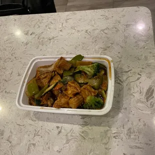 a bowl of stir fried chicken and broccoli