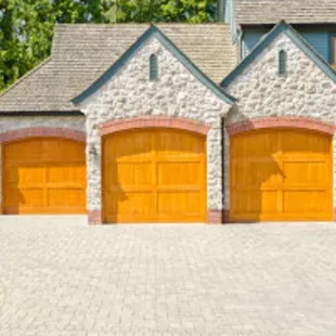 a brick driveway and two garages